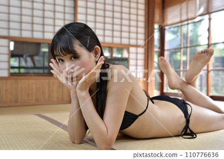 一個穿著黑色比基尼泳裝的年輕女子在老民居的日式房間裡放鬆 110776636