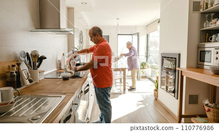 Gay couple working at kitchen and cleaning table Gay couple working at kitchen and cleaning table 110776986
