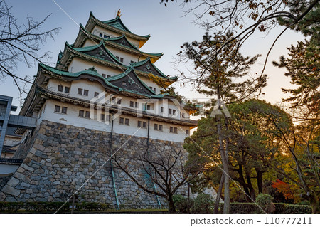 Nagoya castle tower illuminated by the setting sun 110777211