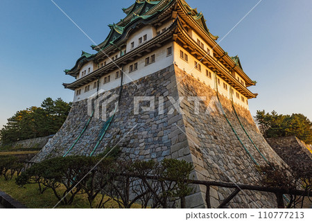 Nagoya castle tower illuminated by the setting sun 110777213