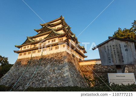 Nagoya castle tower illuminated by the setting sun 110777215
