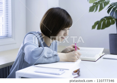 A young woman studying 110777346