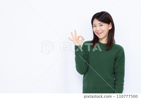 一名 40 多歲的女性做出「OK」手勢 110777500