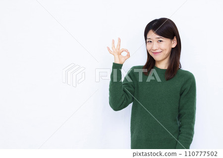 A woman in her 40s giving an OK sign 110777502