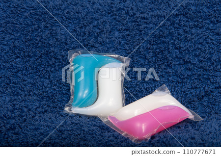 Washing color gel capsule on the brown cloth texture Washing color gel capsule on the brown cloth texture 110777671