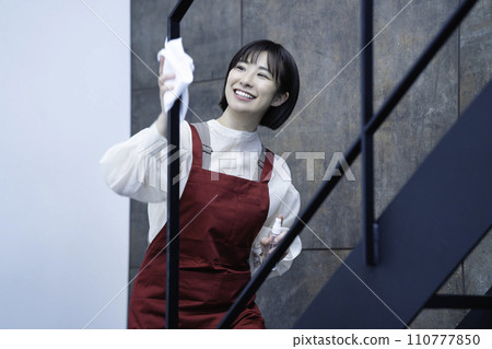 A woman in an apron wiping clean A woman in an apron wiping clean 110777850