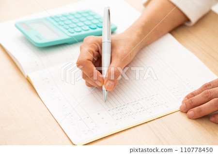 A middle-aged woman keeping a household account book A middle-aged woman keeping a household account book 110778450