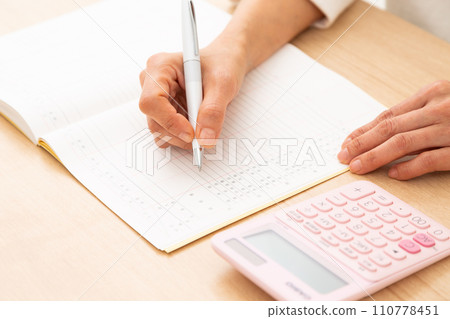 A middle-aged woman keeping a household account book A middle-aged woman keeping a household account book 110778451