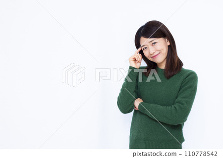 A woman in her 40s thinking with a smile 110778542