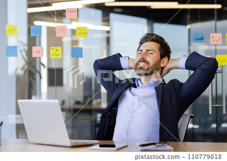 Businessman mature, experienced well done successfully completed project, hands behind head rests, smiles with closed eyes, man at workplace inside office sitting on a chair dreaming and thinking. 110779818