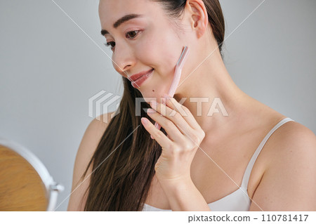 一名 30 多歲的女性用女士刮鬍刀刮臉 一名 30 多歲的女性用女士刮鬍刀刮臉 110781417