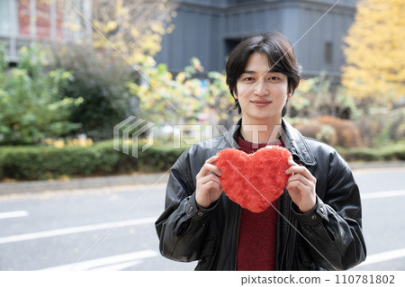 穿著皮夾克、拿著紅心的年輕人 110781802