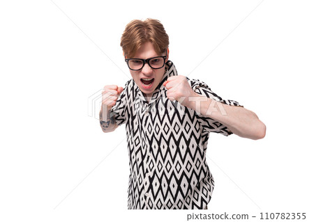 a young caucasian guy with red hair dressed in a shirt has poor eyesight and wears glasses 110782355