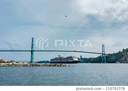 View of ocean harbor with huge ocean cruise liner passing Lion Gates Bridge View of ocean harbor with huge ocean cruise liner passing Lion Gates Bridge 110782376
