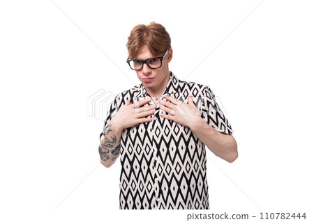 portrait of a young red-haired guy in glasses with poor eyesight 110782444