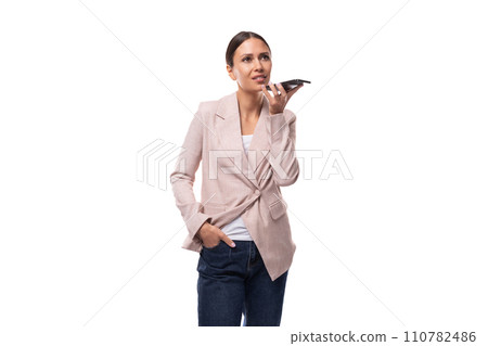 young confident caucasian woman with a ponytail hairstyle is dressed in a jacket and jeans calls by 110782486