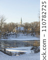Winter city landscapes of Kuldiga, Latvia. Ancient buildings through a pattern of trees. Vertical frame. he Evangelical Lutheran Church of Saint Catherine. View from across the Venta Rive. High 110782725