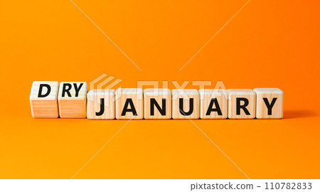 Dry January challenge symbol. Concept words Dry January on beautiful wooden cubes. Beautiful orange table orange background. Dry January healthy lifestyle concept. Copy space. Dry January challenge symbol. Concept words Dry January on beautiful wooden cubes. Beautiful orange table orange background. Dry January healthy lifestyle concept. Copy space. 110782833