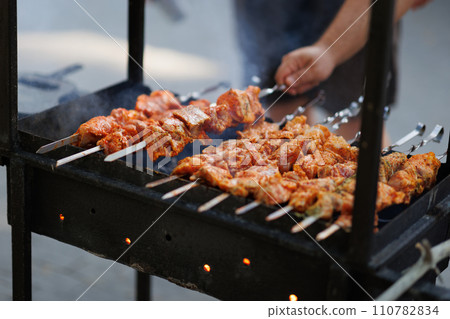 Bar-B-Q or BBQ with kebab cooking. Charcoal grill of meat skewers. Bar-B-Q or BBQ with kebab cooking. Charcoal grill of meat skewers. 110782834