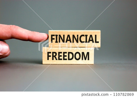 Financial freedom symbol. Concept words Financial freedom on beautiful wooden blocks. Beautiful grey table grey background. Businessman hand. Business financial freedom concept. Copy space. Financial freedom symbol. Concept words Financial freedom on beautiful wooden blocks. Beautiful grey table grey background. Businessman hand. Business financial freedom concept. Copy space. 110782869
