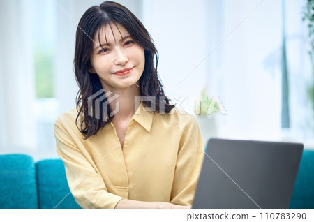 Woman operating a computer at home Woman operating a computer at home 110783290