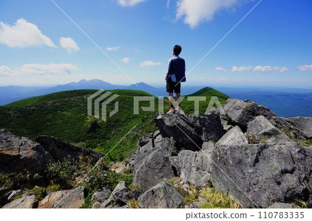Climber looking at the scenery from the peak of Mt. Oakandake 110783335