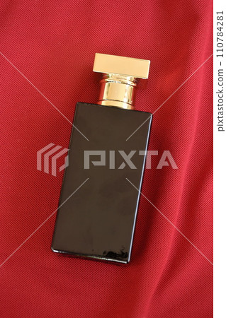 perfume or eau de toilette in black square glass bottle arranging on red fabric background perfume or eau de toilette in black square glass bottle arranging on red fabric background 110784281
