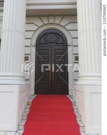 Entrance to a temple-style building with a red carpet 110784865