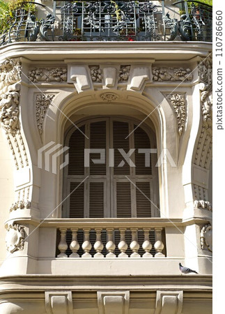 beautiful windows with shutters . Beautiful wooden window shutter with windowsill, cement wall and sunny day 110786660