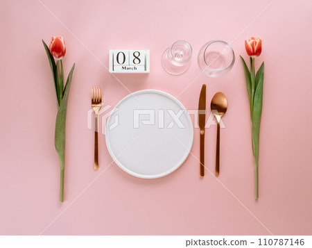 8 march table setting. Empty white plate, calendar with march eight date and red tulip on pink background. Aesthetic stylish dinner table setting for Women's day. Copy space. Flat lay 8 march table setting. Empty white plate, calendar with march eight date and red tulip on pink background. Aesthetic stylish dinner table setting for Women's day. Copy space. Flat lay 110787146