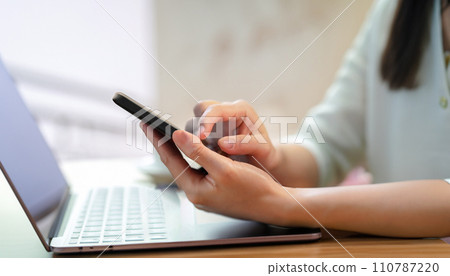 Hand of a woman who operates a smartphone Hand of a woman who operates a smartphone 110787220