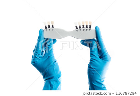 Hands in blue gloves holding dental color palette isolated 110787284