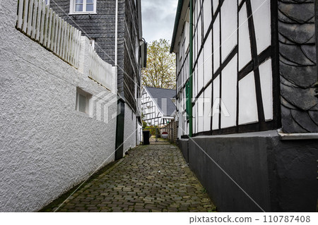 Narrow street with paving stones 110787408