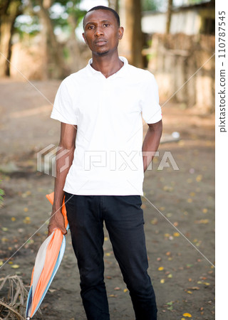 Portrait of a man standing outdoors holding umbrella Portrait of a man standing outdoors holding umbrella 110787545