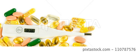 Medicines in capsules and thermometer isolated on white. There is space for text. Wide photo. Medicines in capsules and thermometer isolated on white. There is space for text. Wide photo. 110787576