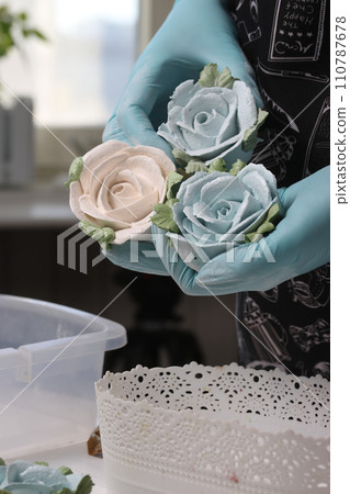 A woman shows flowers made of marshmallows.  Homemade zeohyr. An entrepreneur at work. 110787678