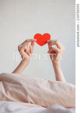 women's hands holding red heart shaped postcard, surprise gift for Valentine's day. women's hands holding red heart shaped postcard, surprise gift for Valentine's day. 110788305
