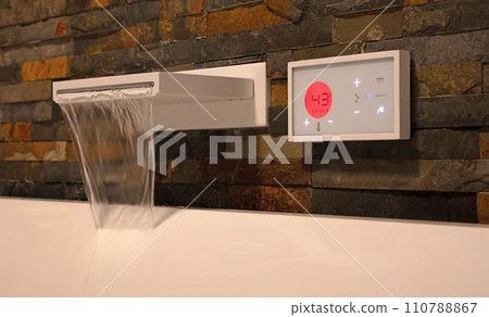 Modern digital watertap, filling the white bath Modern digital watertap, filling the white bath 110788867