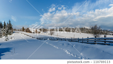 Countryside hills, groves and farmlands in winter remote alpine mountain village 110789113