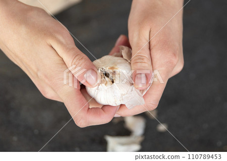 Peeled garlic clove with slices in stack is isolated on white background with clipping path. Peeled garlic clove with slices in stack is isolated on white background with clipping path. 110789453