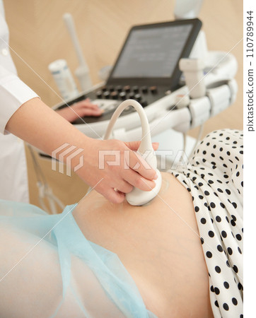 Ultrasound scan of pregnant woman In hospital, doctor performs an ultrasound sonogram on pregnant woman. Ultrasound scan of pregnant woman In hospital, doctor performs an ultrasound sonogram on pregnant woman. 110789944
