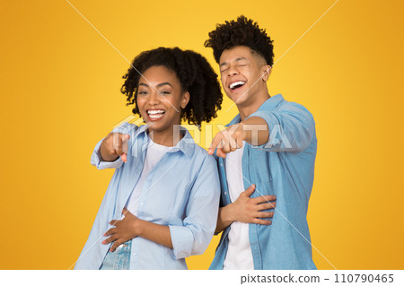 Laughing heartily, a young woman and a young man stand close to each other 110790465