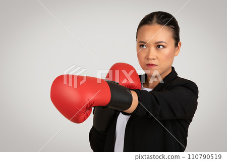Determined Asian businesswoman in a suit with a serious expression Determined Asian businesswoman in a suit with a serious expression 110790519