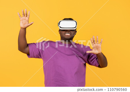 black man engrossed in simulation game via VR headset, studio black man engrossed in simulation game via VR headset, studio 110790560