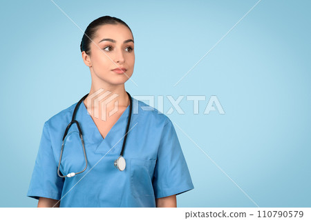 Portrait of european lady nurse posing and looking at free space isolated over blue studio background Portrait of european lady nurse posing and looking at free space isolated over blue studio background 110790579