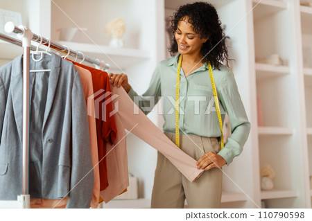 Fashion designer examines fabric quality in studio Fashion designer examines fabric quality in studio 110790598