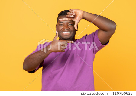 Cheerful african american guy making picture frame with fingers, studio Cheerful african american guy making picture frame with fingers, studio 110790623