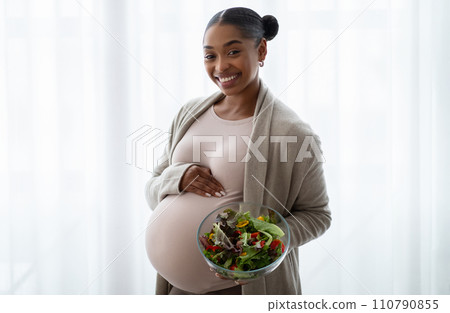 Smiling african american pregnant woman showing her lunch 110790855