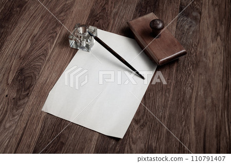Vintage fountain pen and empty sheet of paper on a wooden table Vintage fountain pen and empty sheet of paper on a wooden table 110791407