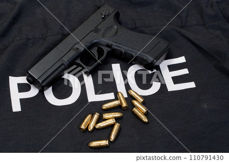 Police black uniform and handgun with cartridges background 110791430